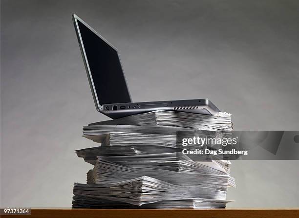 laptop on pile of documents - dag stock pictures, royalty-free photos & images