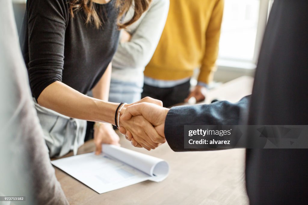 Gens d'affaires se serrant la main dans le bureau