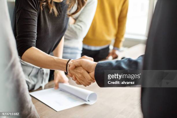 uomini d'affari che si stringono la mano in ufficio - corporate business foto e immagini stock