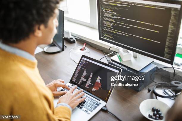 programador de computadoras trabajando en su escritorio - working behind laptop fotografías e imágenes de stock