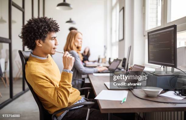 computer-programmierer, die über neue software im büro arbeiten - software stock-fotos und bilder