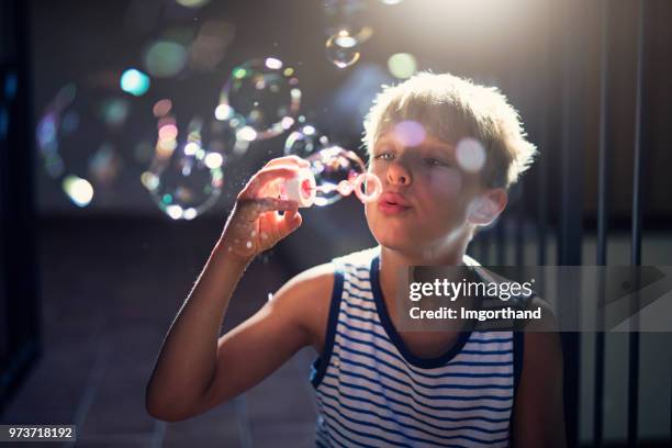 bambino che si diverte a soffiare bolle - blowing bubbles foto e immagini stock