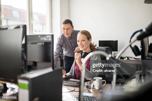 zakelijke professionals werken samen aan computer - colleagues supporting stockfoto's en -beelden