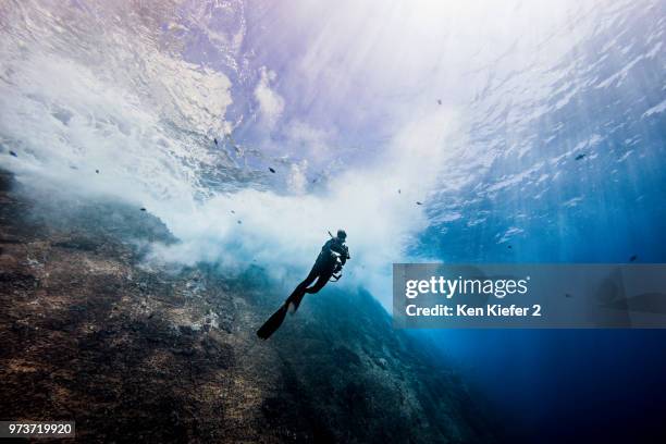 underwater view of female diver exploring roca partida pinnacle, socorro, baja california, mexico - roca partida imagens e fotografias de stock