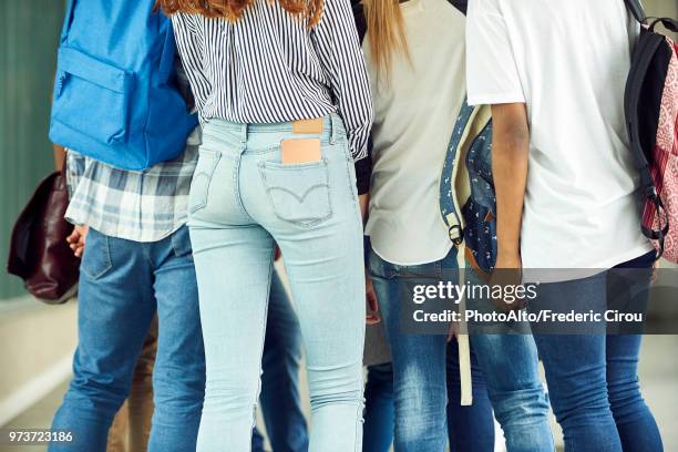 group of students dressed in jeans, cropped rear view - femme entre deux hommes photos et images de collection