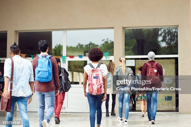 college students walking on campus, rear view - accoglienza foto e immagini stock