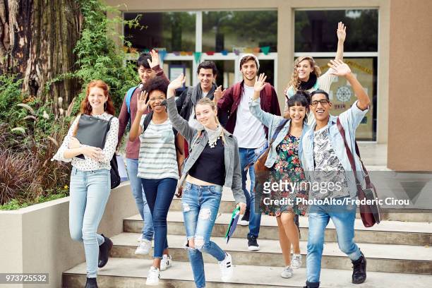 college students waving while walking on campus - woman waving goodbye photos et images de collection