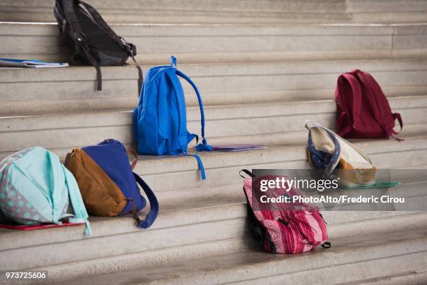 backpacks left on bleachers - school bag stock-fotos und bilder