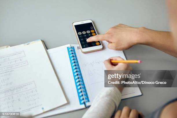 students using smartphone calculator function while completing math assignment - math tutor stock pictures, royalty-free photos & images