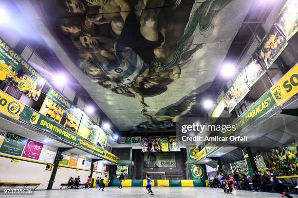 Young players run during a soccer match at Sportivo Pereyra de Barracas Club on June 13, 2018 in Buenos Aires, Argentina. The mural was painted in...