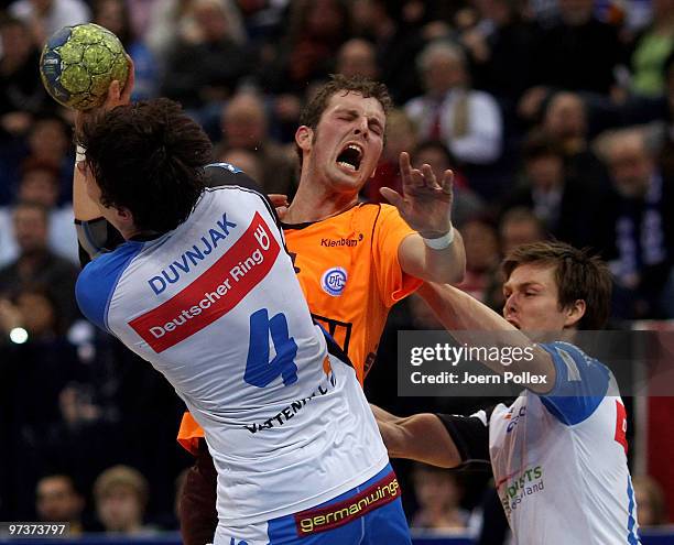 Domagoj Duvnjak and Hans Lindberg of Hamburg and Christoph Schindler of Gummersbach compete for the ball during the Bundesliga match between HSV...