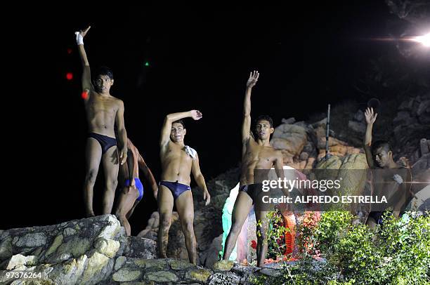 Cliff divers wave to spectators at 'La Quebrada' cliff in Acapulco, Mexico, on March 1, 2010. The tradition of 'La Quebrada' goes back to 1934, when...