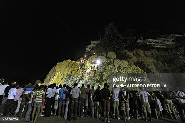 Spectators waitch as cliff divers jump from 'La Quebrada' cliff in Acapulco, Mexico, on March 1, 2010. The tradition of 'La Quebrada' goes back to...