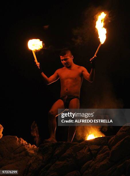 Cliff diver prepares to jump with torches from 'La Quebrada' cliff in Acapulco, Mexico, on March 1, 2010. The tradition of 'La Quebrada' goes back to...