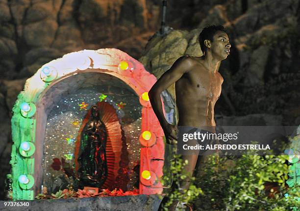 Cliff diver stands next to an altar before jumping from 'La Quebrada' cliff in Acapulco, Mexico, on March 1, 2010. The tradition of 'La Quebrada'...