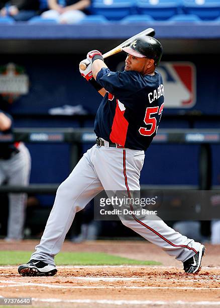 Outfielder Melky Cabrera of the Atlanta Braves follows through on a single in the second inning while taking on the New York Mets during a spring...