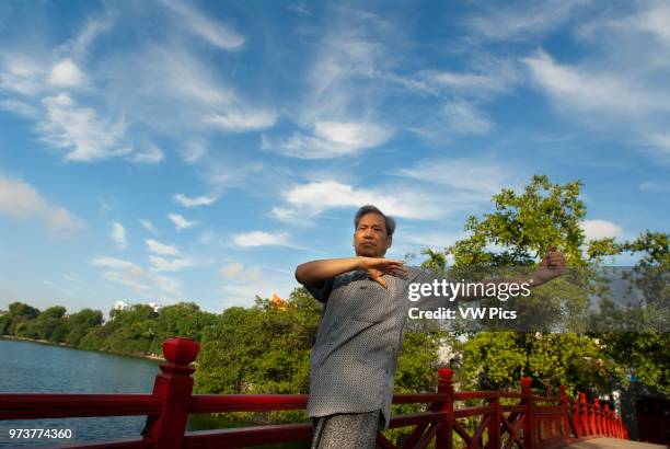 Morning exercise at the The Huc bridge leading to Ngoc Son Temple in Hoan Kiem. Hanoi Old Quarter. Huc Bridge to Ngoc Son Temple, Jade Mountain...