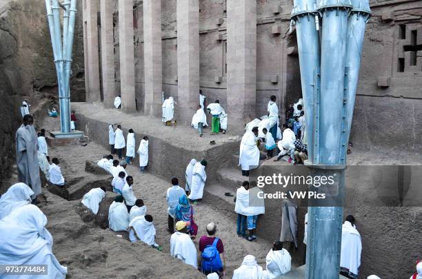 Religious devotees dressed in white worship and pray at Biete Medhane Alem ancient rock-hewn church in Lalibela, Ethiopia.