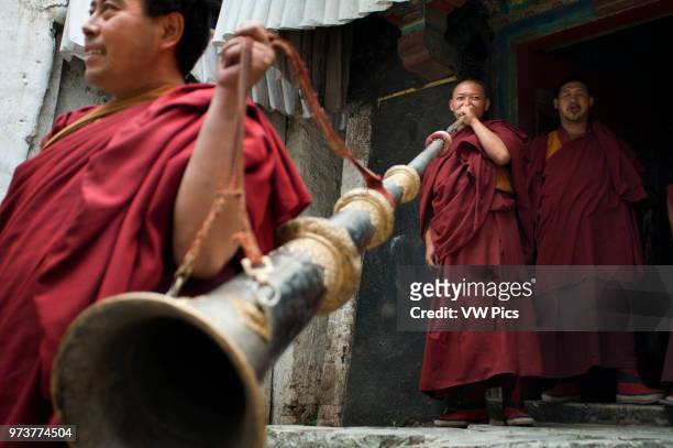 Monks playing the Tibetan horn inside Tashilumpo Monastery at Shigatse, Tibet, China.