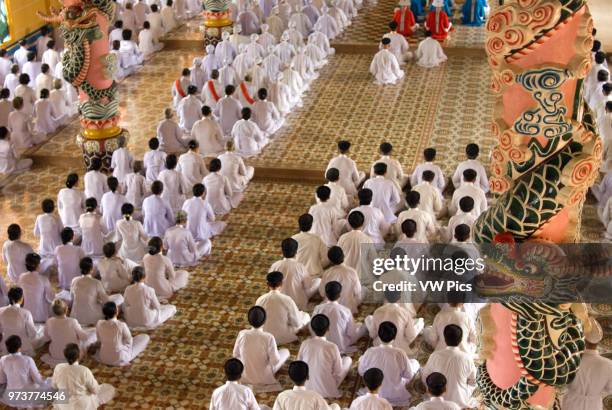 Worshipers at midday prayer in the Cao Dai temple, Tay Ninh, Vietnam, Asia.