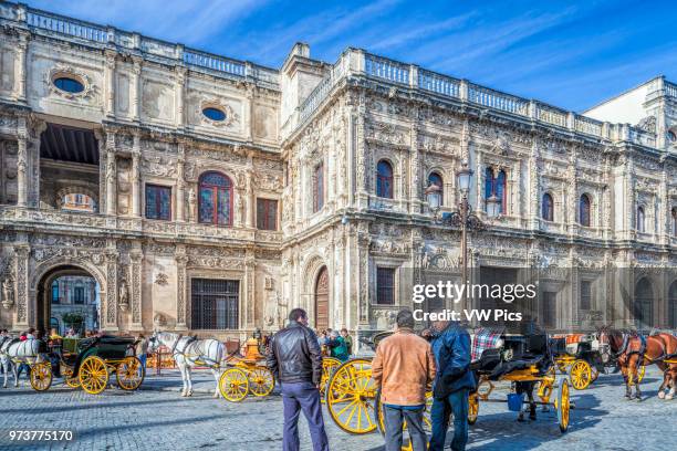 Horse drawn carriages waiting for visitors in front of the plateresque City Hall, San Francisco Square, Seville, Spain.