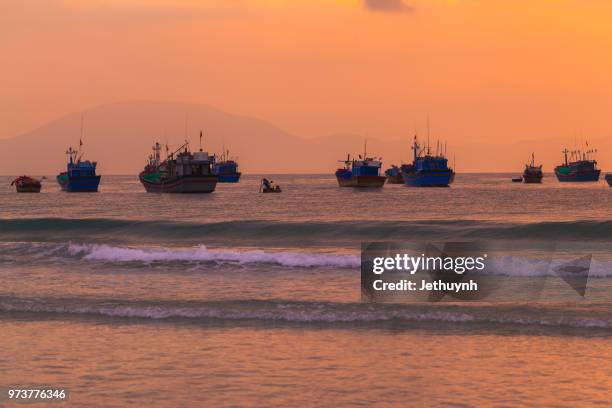 orange dawn at beach with many fishing boats - jethuynh stock pictures, royalty-free photos & images