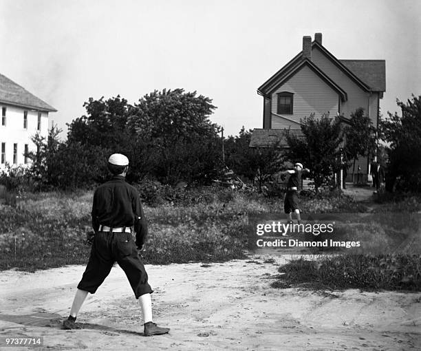 Members of the Socials baseball club play a game of catch in the backyard of a house on July 21, 1907.