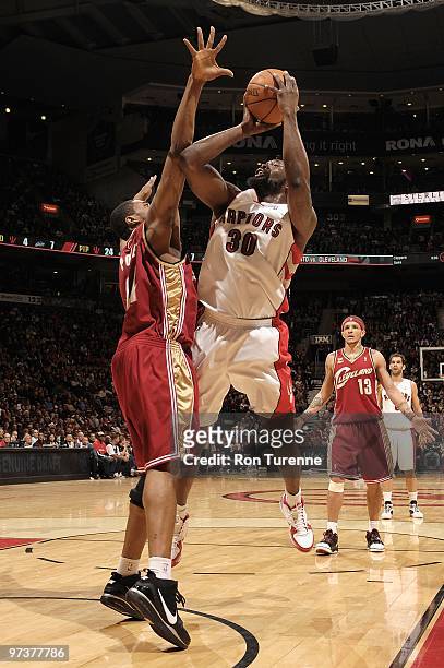 Reggie Evans of the Toronto Raptors shoots against Leon Powe of the Cleveland Cavaliers during the game on February 26, 2010 at Air Canada Centre in...