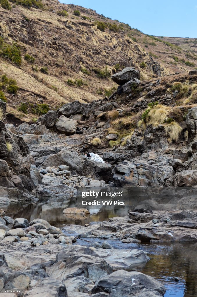An Ethiopian boy sleeps soundly while blending into nature.
