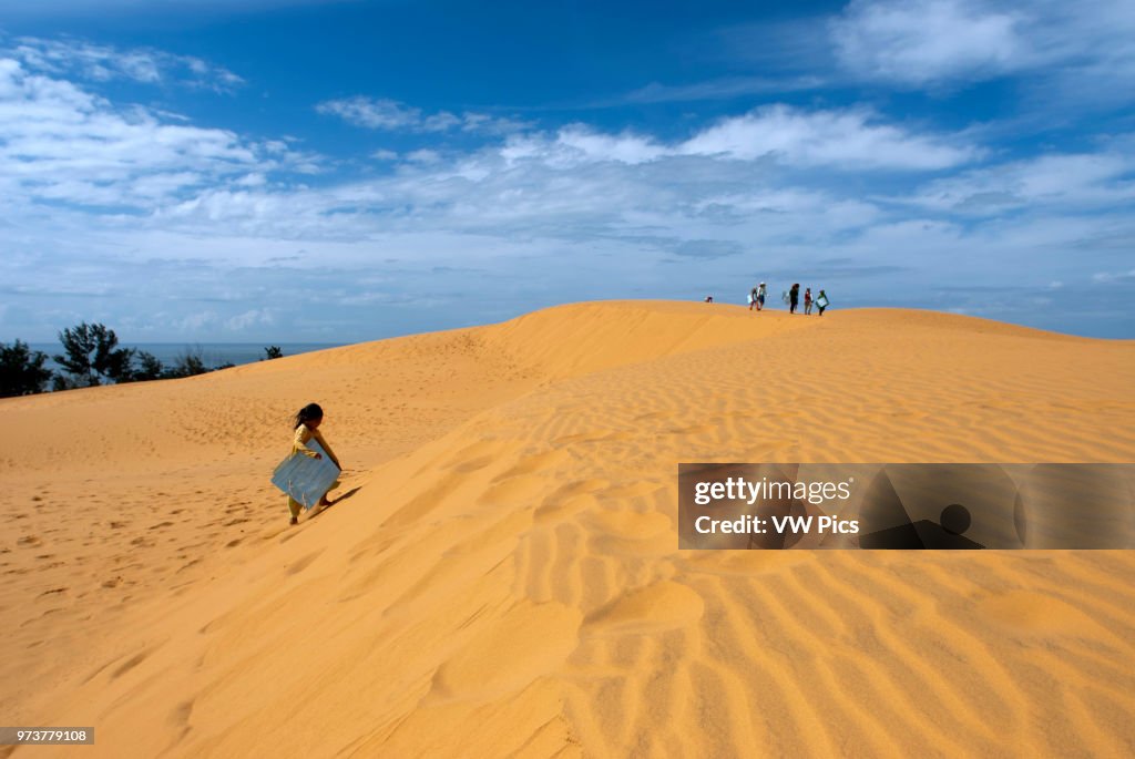 Young people have funthrowing themselves through the desert sand at the White Sand Dunes.