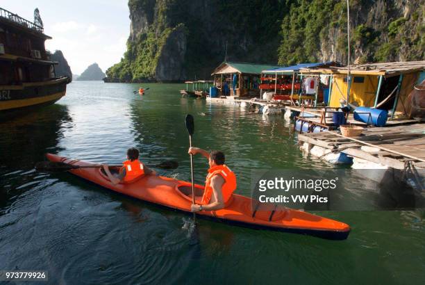 Tourists in Several Kayaks from a Tour Boat in Halong Bay Vietnam. Racers paddling sea kayaks in Halong Bay during an adventure race in Vietnam.