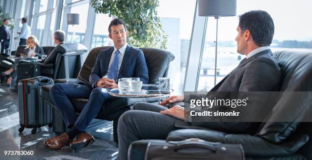 mensen uit het bedrijfsleven zit op stoel op luchthaven - airport lounge luxury stockfoto's en -beelden