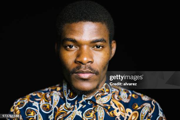 portrait of serious young man on black background - black eye close up stock pictures, royalty-free photos & images