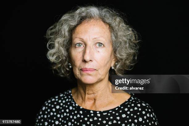 portrait d’une femme senior sur fond noir - women serious face photos et images de collection