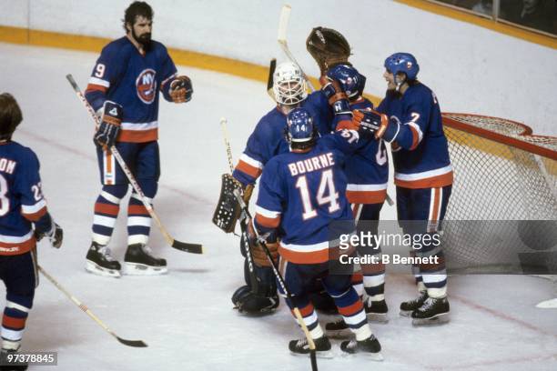 Goaltender Billy Smith of the New York Islanders and his teammates celebrate after winning Game 3 of the 1982 Stanley Cup Finals against the...
