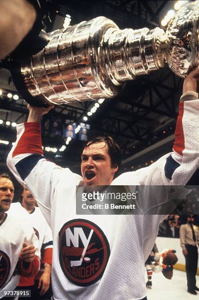Dave Langevin of the New York Islanders hoists the Stanley Cup after the Islanders defeated the Edmonton Oilers 4-2 in Game Four of the 1983 Stanley...