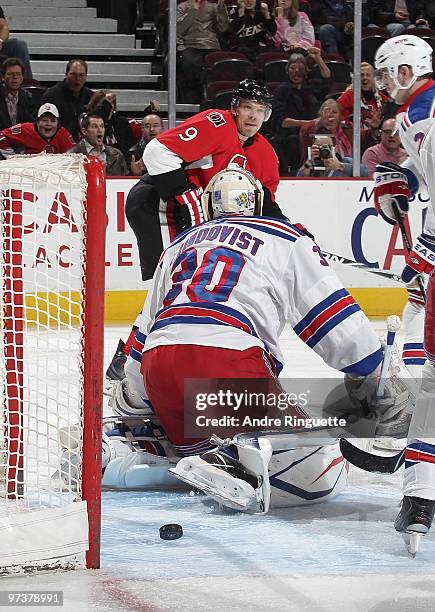 Milan Michalek of the Ottawa Senators watches the puck hit the net behind against Henrik Lundqvist of the New York Rangers as he scores a first...