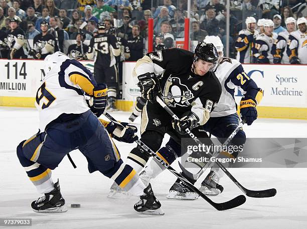 Sidney Crosby of the Pittsburgh Penguins skates between the defense of Derek Roy and Drew Stafford of the Buffalo Sabres on March 2, 2010 at Mellon...