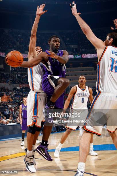 Tyreke Evans of the Sacramento Kings passes the ball around Nenad Krstic of the Oklahoma City Thunder on March 2, 2010 at the Ford Center in Oklahoma...