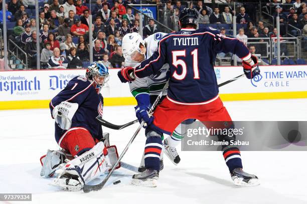 Goaltender Steve Mason of the Columbus Blue Jackets stops the puck as Fedor Tyutin of the Columbus Blue Jackets attempts to keep Steve Bernier of the...