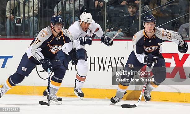 Denis Grebeshkov and Colin Wilson of the Nashville Predators skate against Steve Staios of the Edmonton Oilers on March 2, 2010 at the Bridgestone...