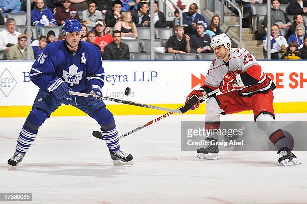Tomas Kaberle of the Toronto Maple Leafs battles for the puck with Tom Kostopoulos of the Carolina Hurricanes during game action March 2, 2010 at the...