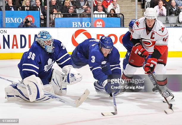 Dion Phaneuf of the Toronto Maple Leafs battles for the puck with Eric Staal of the Carolina Hurricanes in front of goalie Jean-Sebastien Giguere...