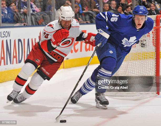 Carl Gunnarsson of the Toronto Maple Leafs skates the puck away from Scott Walker of the Carolina Hurricanes during game action March 2, 2010 at the...