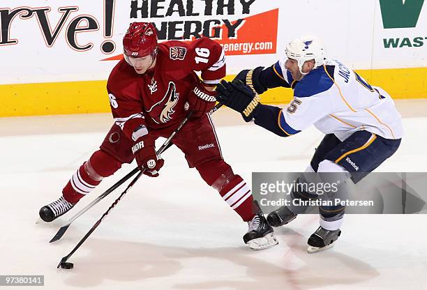 Petr Prucha of the Phoenix Coyotes skates with the puck under pressure from Barret Jackman of the St. Louis Blues during the NHL game at Jobing.com...