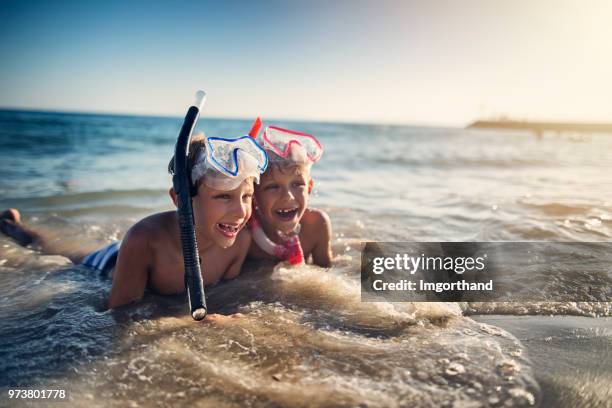 little brothers lying on beach after snorkeling - mergulhador imagens e fotografias de stock