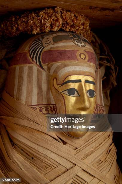 Ptolemaic coffin, mummy with gilt mask and floral garlands, Roman Period , circa 30BC-AD641. Dimension: length: 155 cmwidth: 44 cmArtist Unknown.