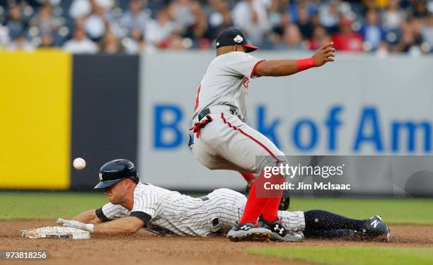 Brett Gardner of the New York Yankees steals second base during the first inning and advances to third base as the ball gets past Wilmer Difo of the...