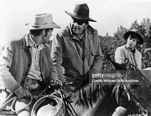 John Wayne, in his Oscar winning performance as Rooster Cogburn, in scene with Kim Darby and Glen Campbell from the movie 'True Grit' directed by...