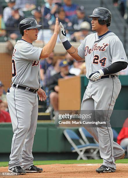 Magglio Ordonez and Miguel Cabrera of the Detroit Tigers high-five after scoring runs during the spring training game against Florida Southern...